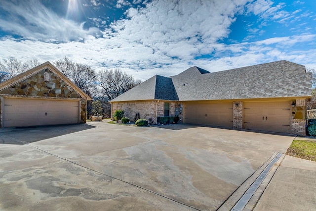 view of side of home featuring a garage, brick siding, concrete driveway, and roof with shingles