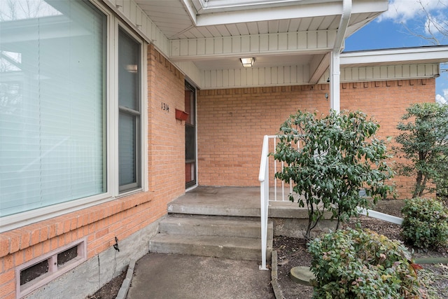 view of exterior entry with brick siding