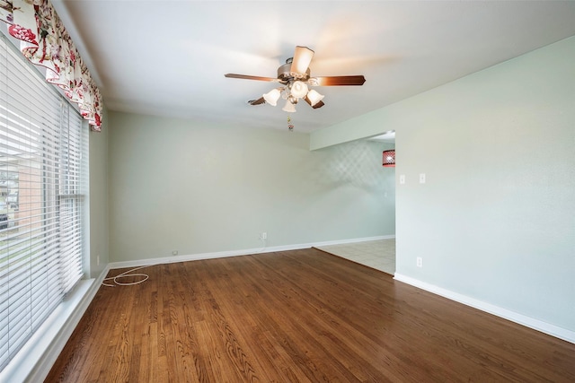 spare room with a ceiling fan, baseboards, and wood finished floors