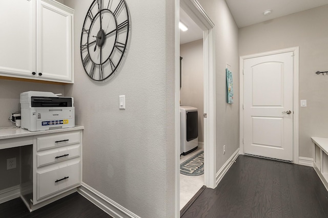 hall with washer / dryer, baseboards, and dark wood-style flooring