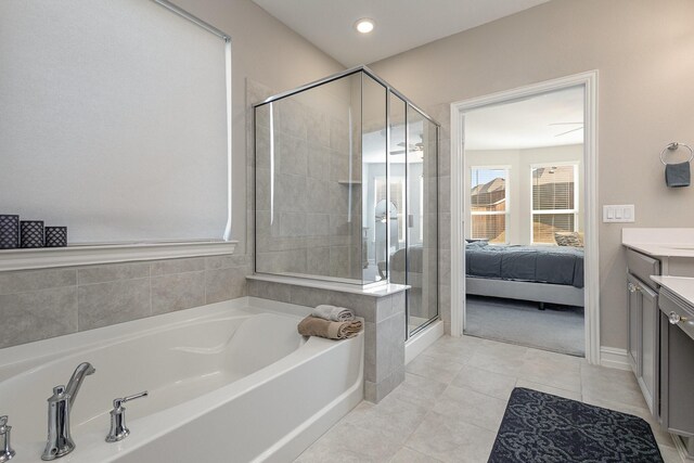 full bathroom featuring ensuite bathroom, tile patterned flooring, vanity, a bath, and a stall shower