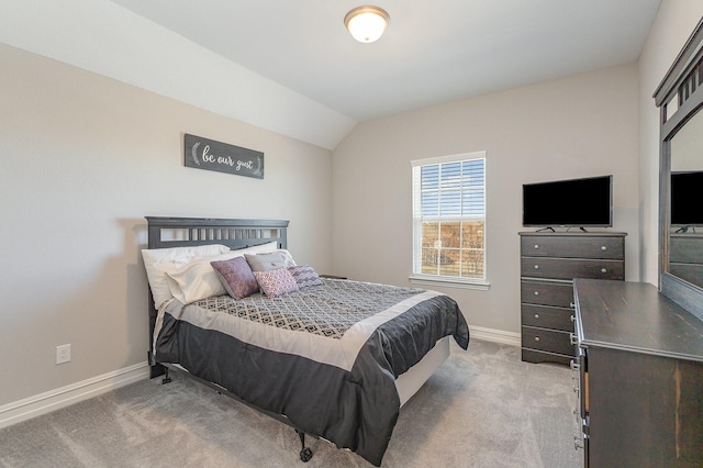 bedroom featuring light carpet, vaulted ceiling, and baseboards