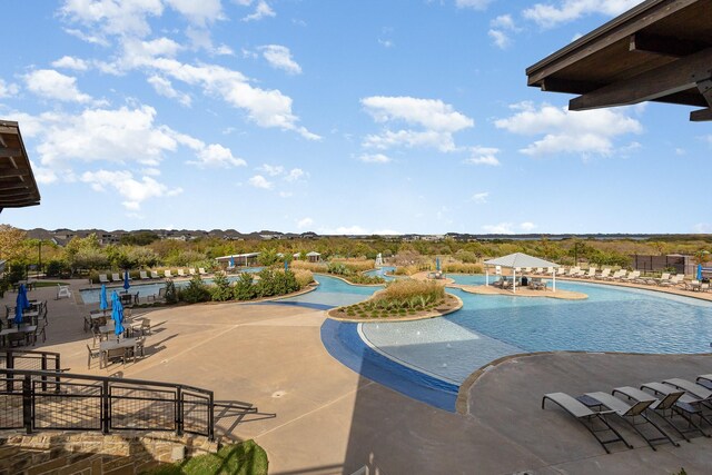 community pool with a patio, a gazebo, and fence