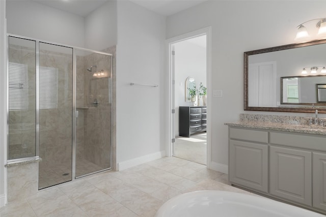 full bathroom with a stall shower, baseboards, and vanity