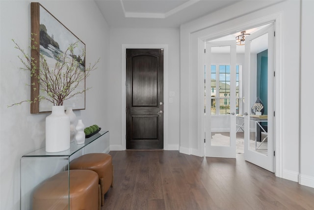 foyer entrance featuring baseboards and wood finished floors