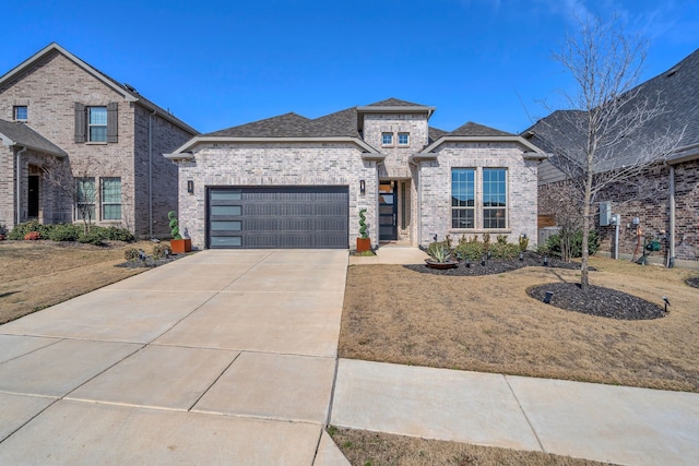 view of front of property with a garage, brick siding, concrete driveway, roof with shingles, and a front yard