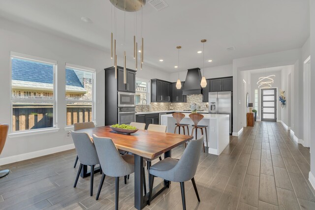 dining space featuring wood tiled floor, visible vents, baseboards, and recessed lighting