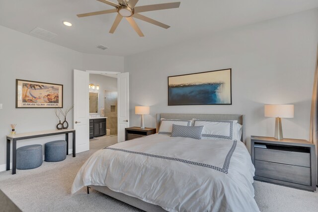 bedroom with recessed lighting, light colored carpet, visible vents, a ceiling fan, and ensuite bath