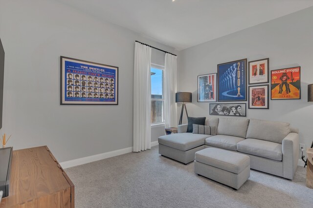 living room featuring light carpet and baseboards