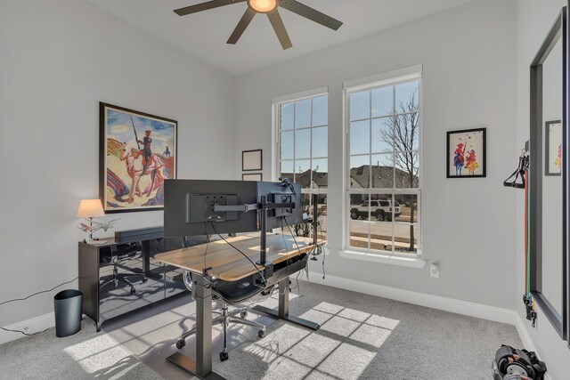 office space featuring ceiling fan, baseboards, and light colored carpet