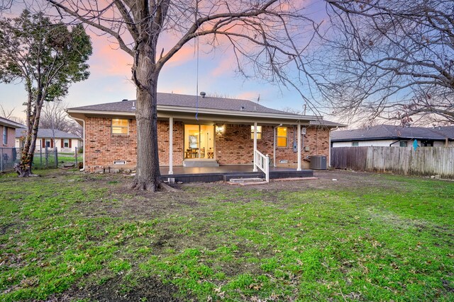 wooden terrace with central AC, a yard, and a fenced backyard