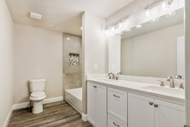 full bathroom featuring visible vents, a sink, baseboards, and wood finished floors