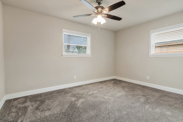 carpeted spare room with ceiling fan and baseboards