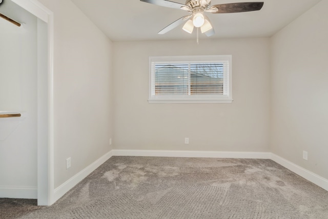 carpeted empty room featuring ceiling fan and baseboards