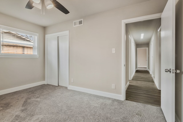 unfurnished bedroom with carpet floors, visible vents, and baseboards