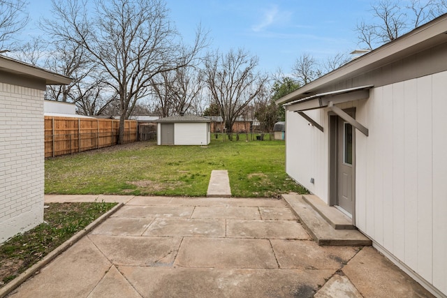 view of yard with a fenced backyard, a patio, an outdoor structure, and a shed