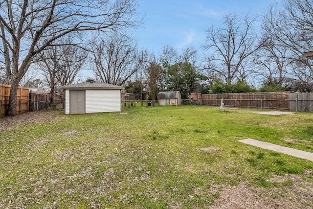 view of yard featuring an outbuilding, a shed, and a fenced backyard