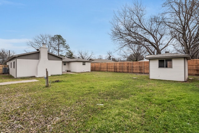 view of yard with a fenced backyard and an outbuilding