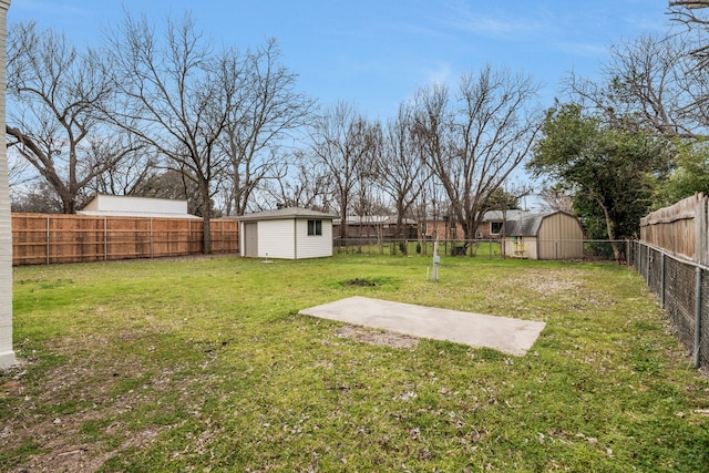 view of yard featuring a storage shed, an outdoor structure, and a fenced backyard