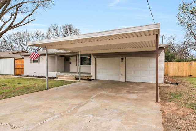 view of front of home featuring driveway, an attached garage, fence, a front lawn, and brick siding