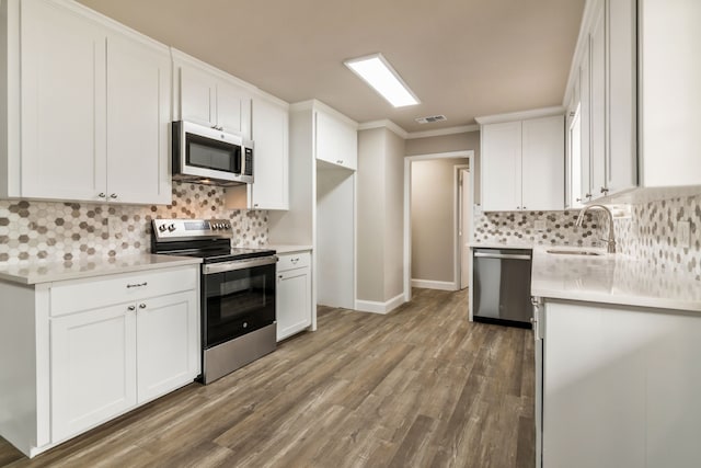 kitchen featuring light countertops, visible vents, appliances with stainless steel finishes, white cabinetry, and a sink