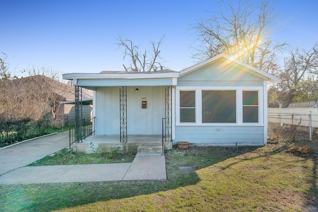 bungalow-style house featuring a porch, a front yard, and fence