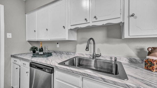 kitchen featuring dishwasher, light countertops, a sink, and white cabinetry