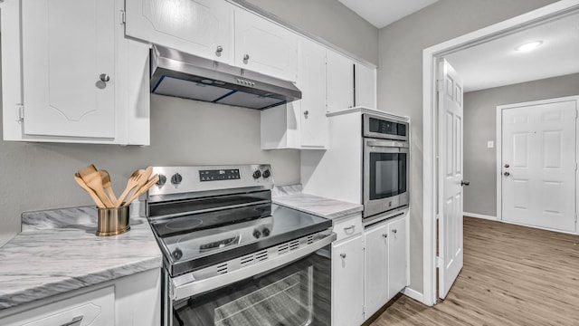 kitchen featuring baseboards, light wood-style flooring, stainless steel appliances, under cabinet range hood, and white cabinetry