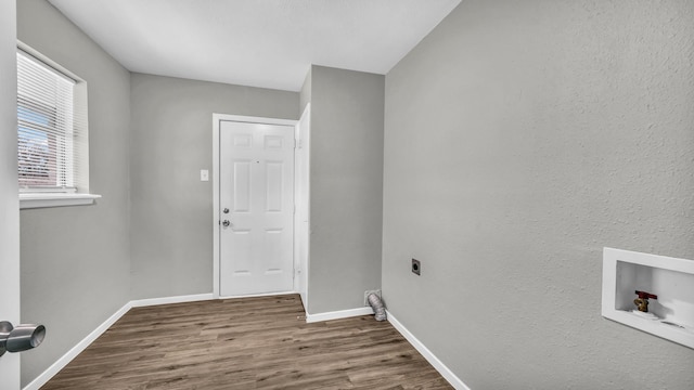 clothes washing area featuring washer hookup, hookup for an electric dryer, wood finished floors, laundry area, and baseboards