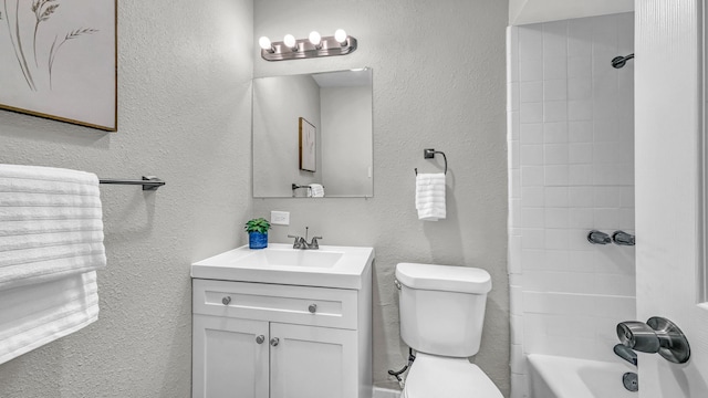 bathroom with a textured wall, vanity, toilet, and shower / bathtub combination