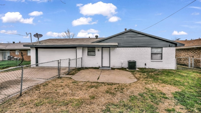 rear view of property featuring central AC unit, a lawn, concrete driveway, an attached garage, and fence