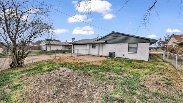 back of property with central air condition unit, fence private yard, a gate, and a lawn