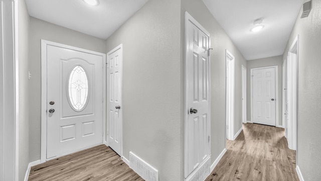 entryway featuring baseboards, visible vents, and light wood finished floors