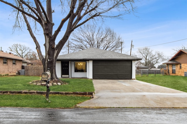 view of front facade with an attached garage, fence, concrete driveway, and a front yard