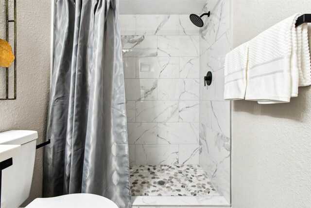 full bath with a textured wall and a stall shower