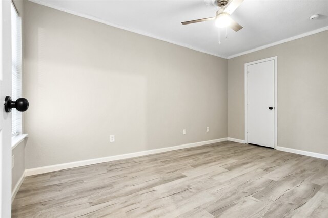 spare room featuring light wood-style flooring, baseboards, a ceiling fan, and ornamental molding