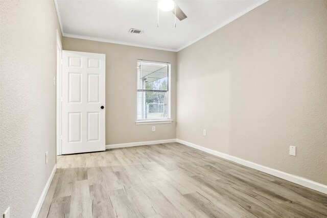 unfurnished room with visible vents, crown molding, light wood-style flooring, and baseboards