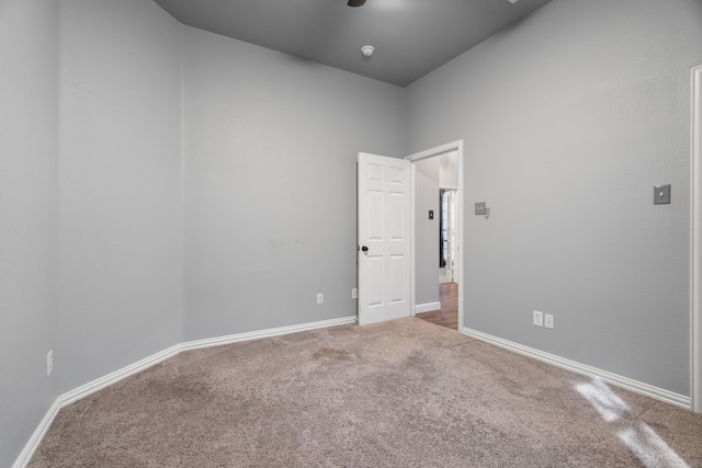 carpeted spare room featuring baseboards