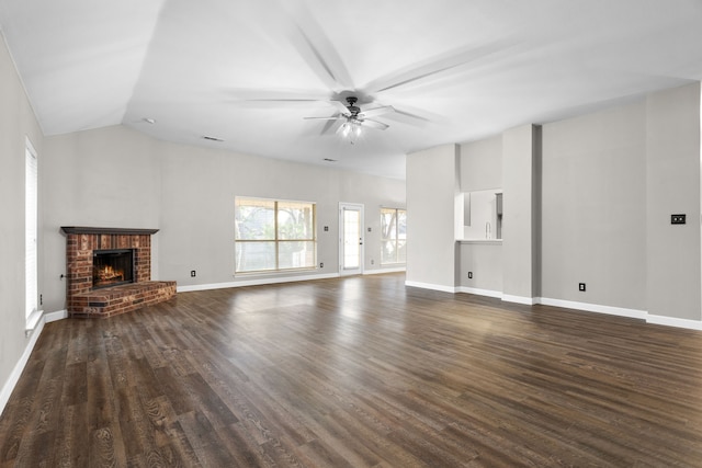 unfurnished living room featuring ceiling fan, a fireplace, dark wood finished floors, and baseboards