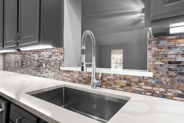 interior details featuring gray cabinets, backsplash, and a sink