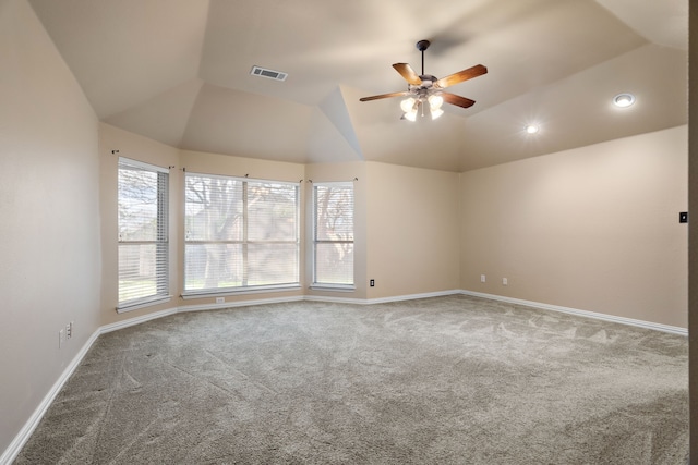 empty room featuring lofted ceiling, carpet, visible vents, and baseboards