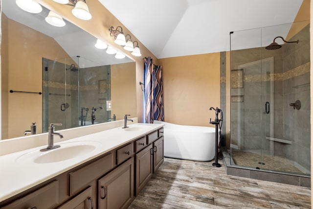 bathroom featuring a freestanding tub, vaulted ceiling, and a sink