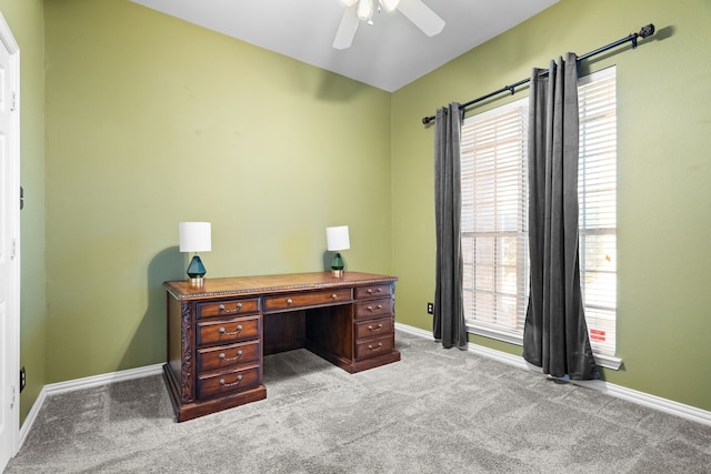 home office with baseboards, a ceiling fan, and light colored carpet