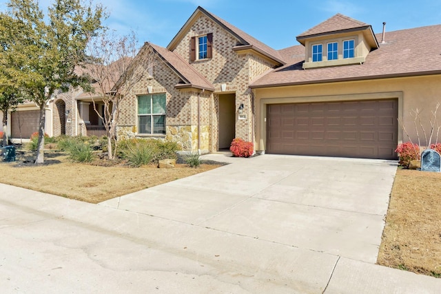 view of front facade with a garage, stucco siding, concrete driveway, and roof with shingles