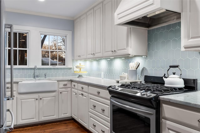 kitchen with a sink, custom exhaust hood, white cabinets, and stainless steel range with gas stovetop