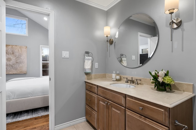 bathroom featuring ensuite bath, baseboards, ornamental molding, and vanity