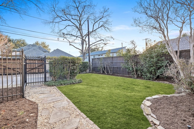 view of yard with a fenced backyard and a gate