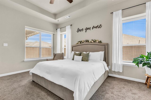 bedroom with baseboards, visible vents, a raised ceiling, a ceiling fan, and carpet floors