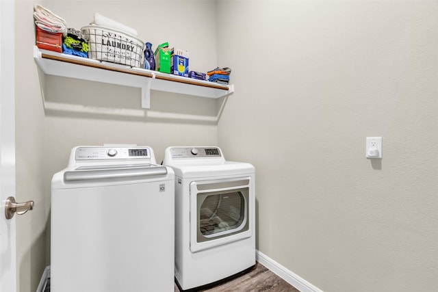 laundry room with laundry area, wood finished floors, washing machine and clothes dryer, and baseboards