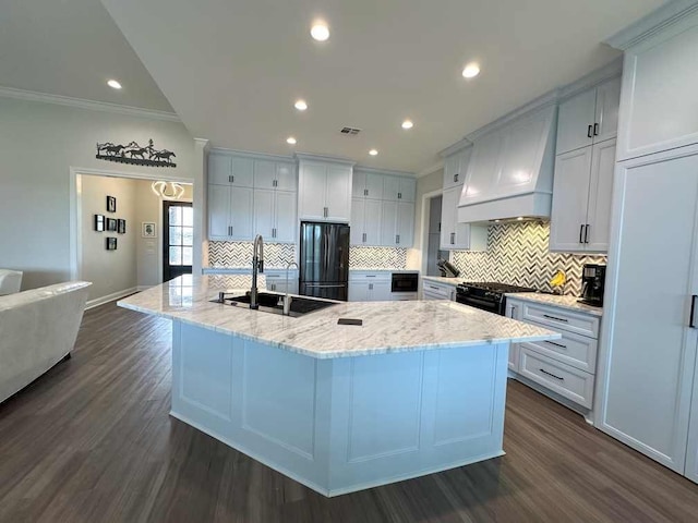 kitchen featuring dark wood-style flooring, custom exhaust hood, a sink, and black appliances